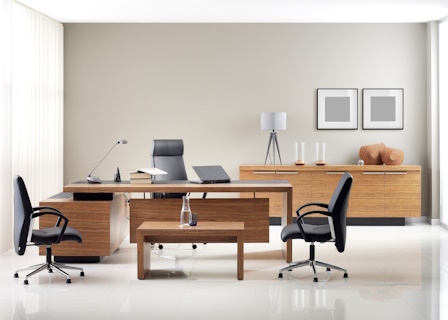 an office with wood desks and furniture and black rolling chairs
