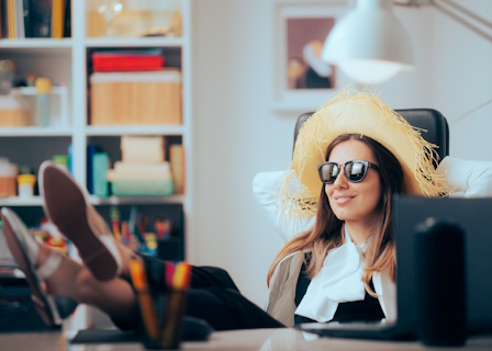 woman with sunglasses and straw hat at office desk