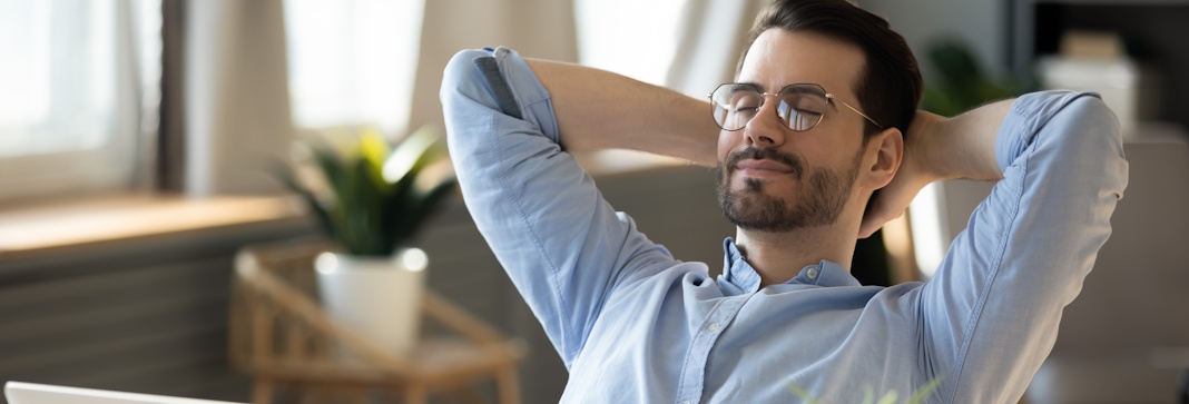man resting in office chair with eyes closed